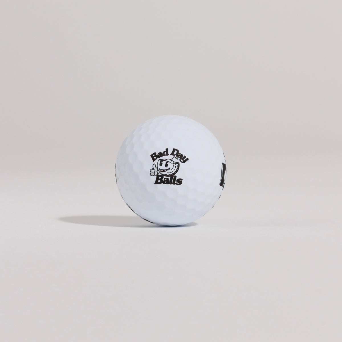 The Mulligan golf ball resting on a tee against a white background, showing main logo
