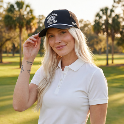 A woman on a golf course wearing a bad day ball hat