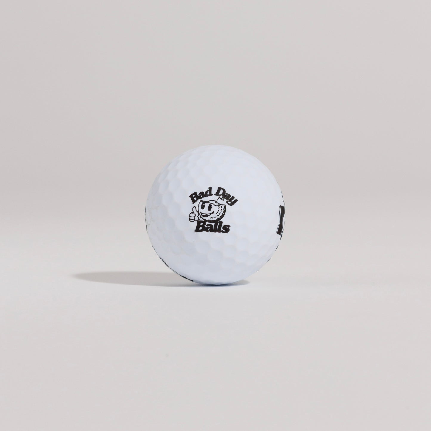 The Mulligan golf ball resting on a tee against a white background, showing main logo