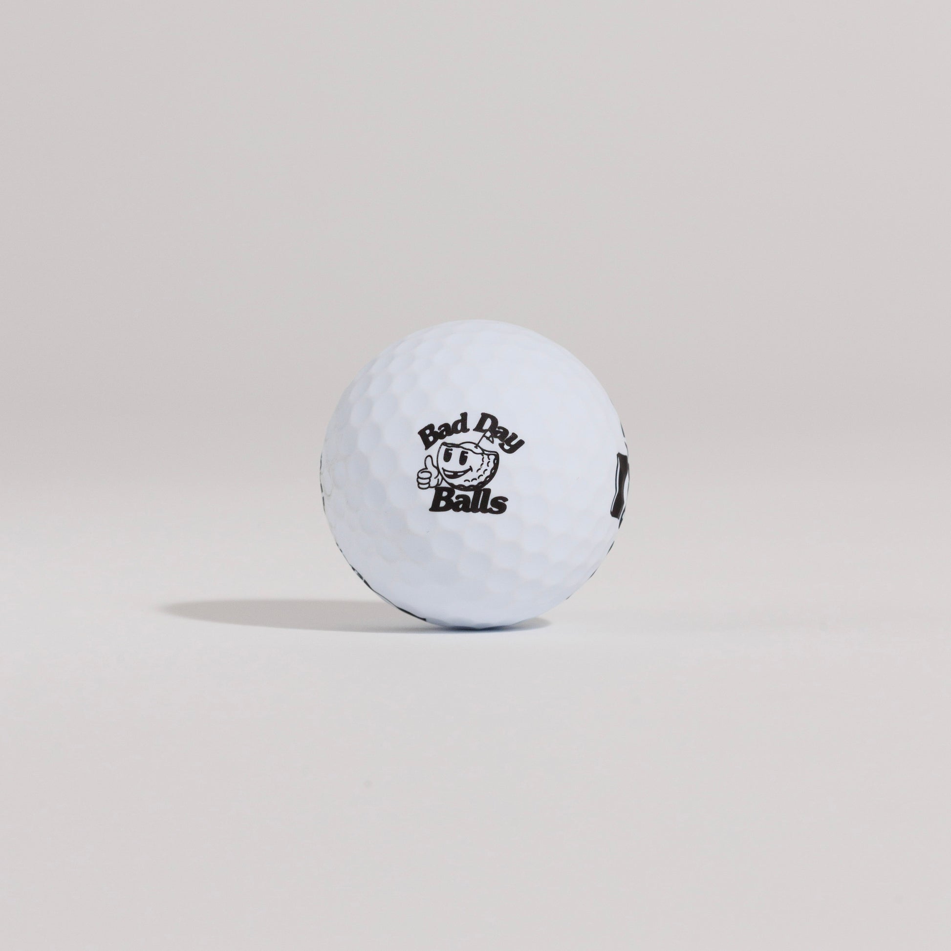 The Mulligan golf ball resting on a tee against a white background, showing main logo