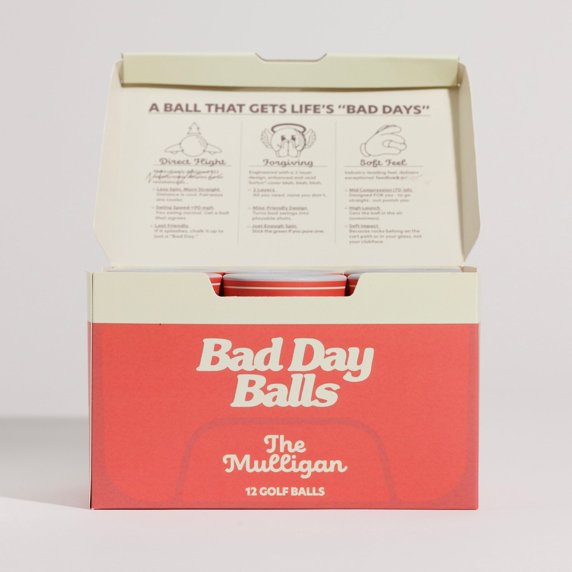 An open cooler for golf balls, with 'Bad Day Balls The Mulligan 12 Golf Balls' 