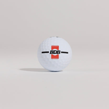 The Mulligan golf ball resting on a tee against a white background, showing BDB can putting and driving alignment tool